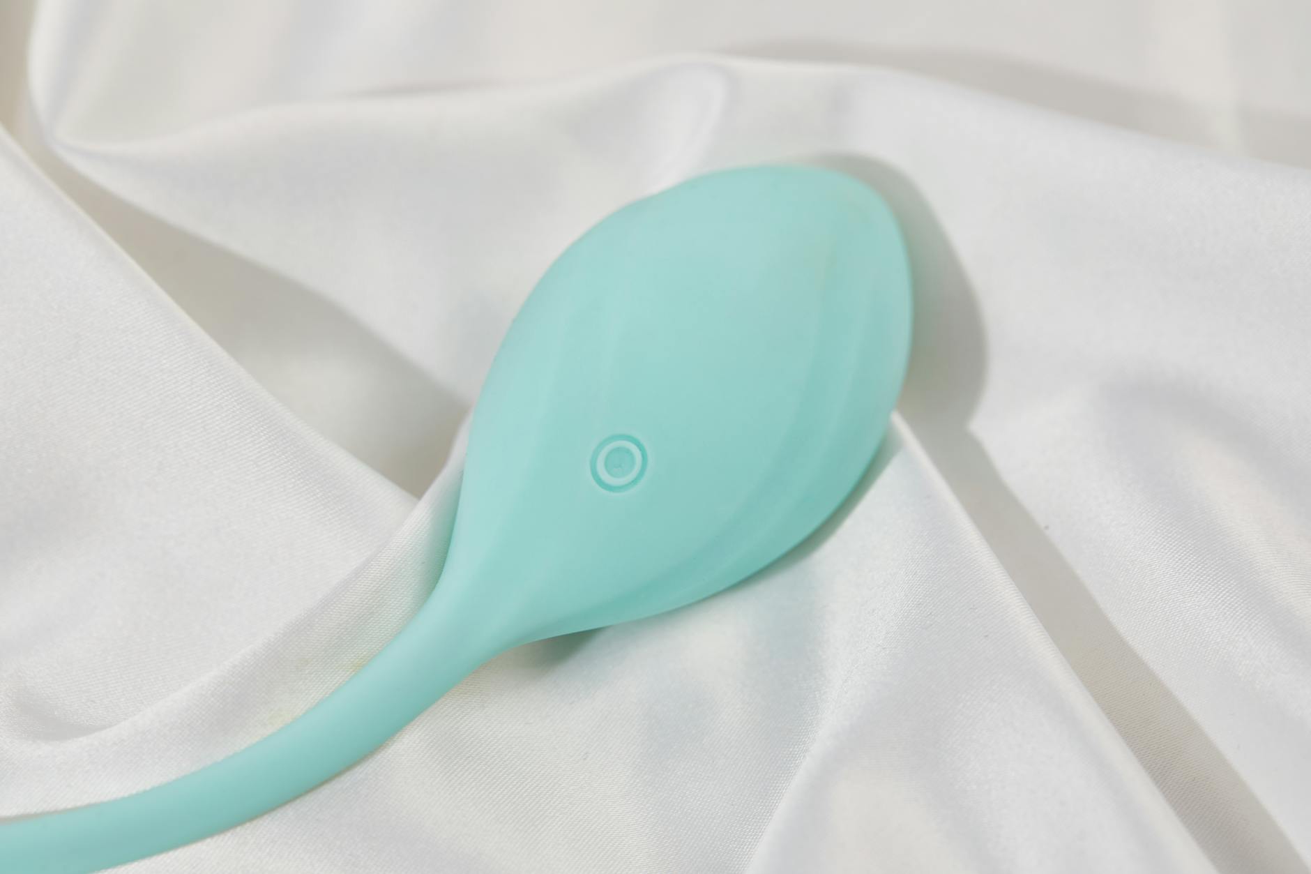 Un vibromasseur citron élégant sur tissu blanc et soie, symbolisant l'exploration consciencieuse du plaisir