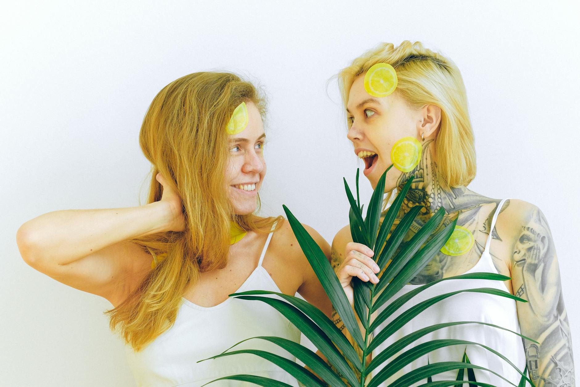 Deux femmes joyeuses tenant des tranches de citron, exprimant la joie et la confiance.