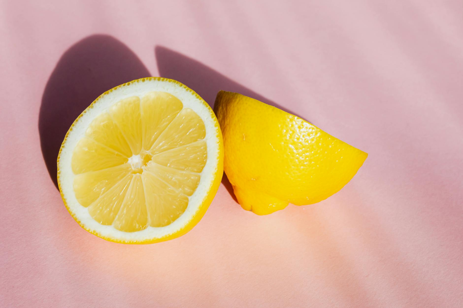 Gros plan d'une main tenant un vibromasseur orange contre un fond minimaliste violet