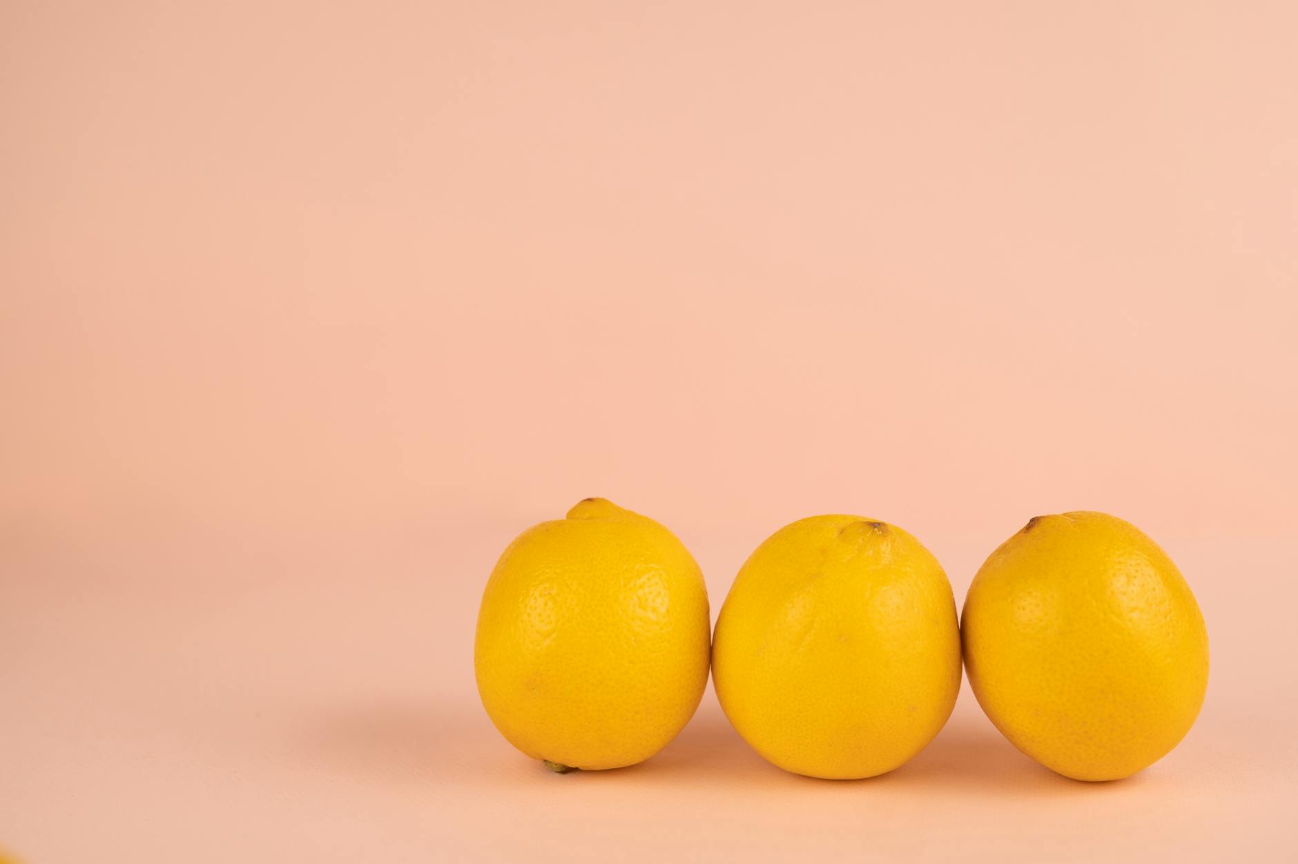 Un vibromasseur citron jaune vif entouré de détails minimalistes sur fond jaune pastel