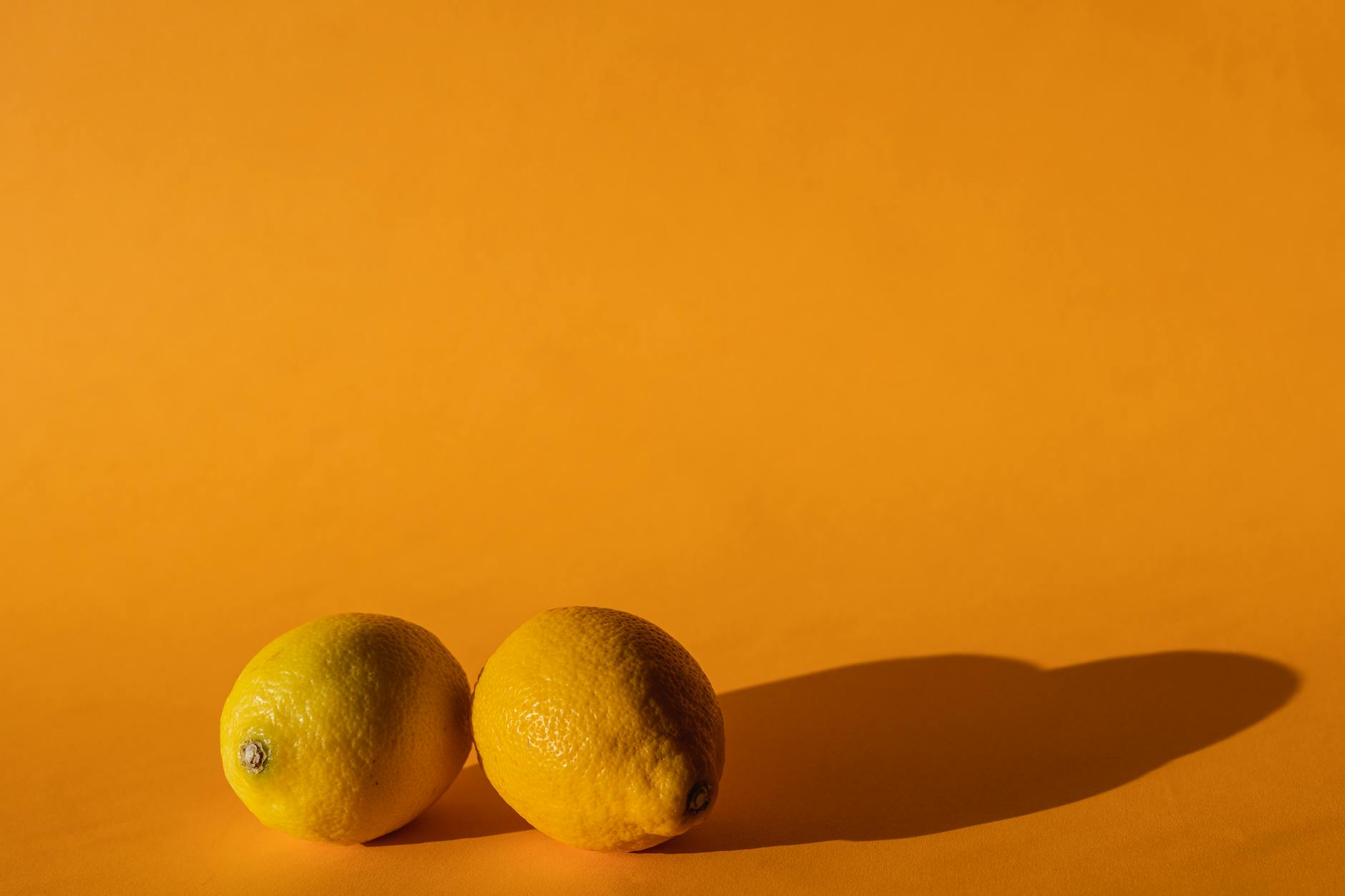 Vibromasseur citron jaune en silicone sur fond jaune avec des bananes pelées